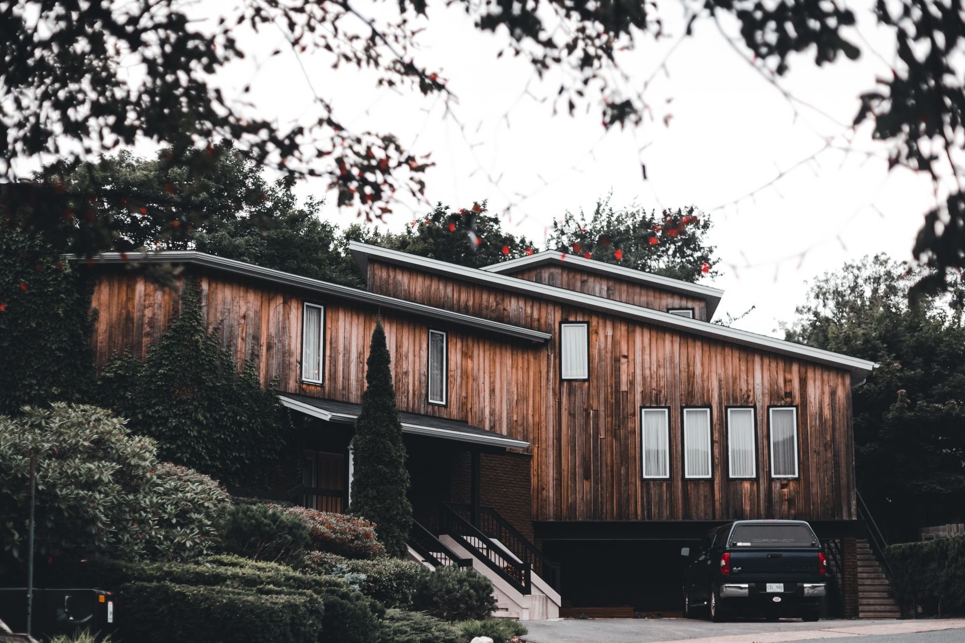 Stylish dark wood home exterior surrounded by Pacific Northwest greenery.