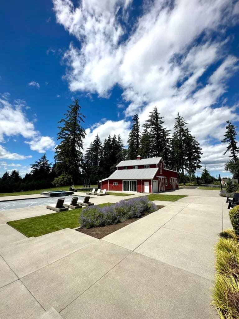 Beautifully maintained estate with clean concrete pool deck, red barn, lavender garden, and Pacific Northwest landscape