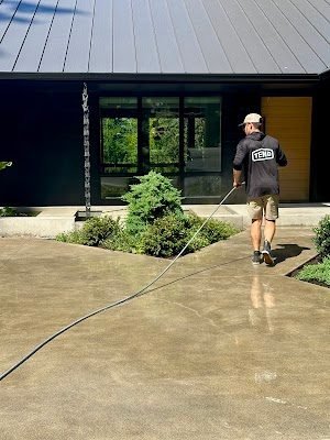Tend technician walking with hose at a modern home